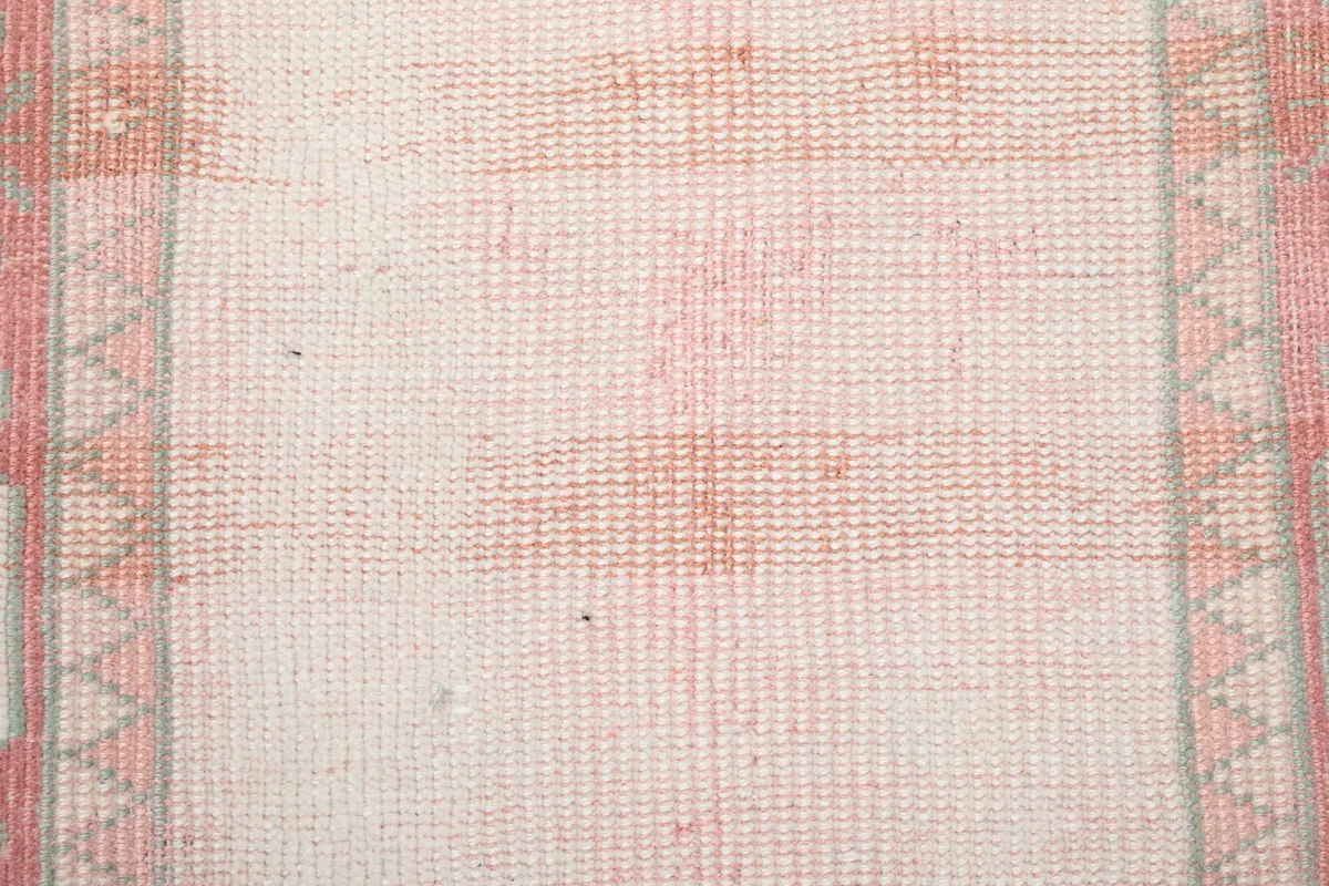 Texture detail of the hand-knotted wool pile and subtle color shifts in the rug's field