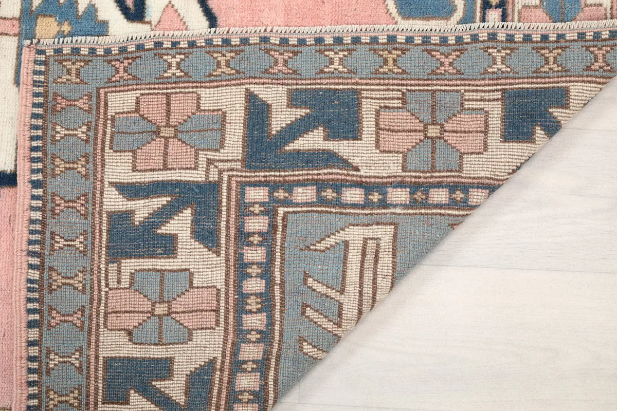 Underside view of the rug's corner, revealing the cotton foundation and knotting
