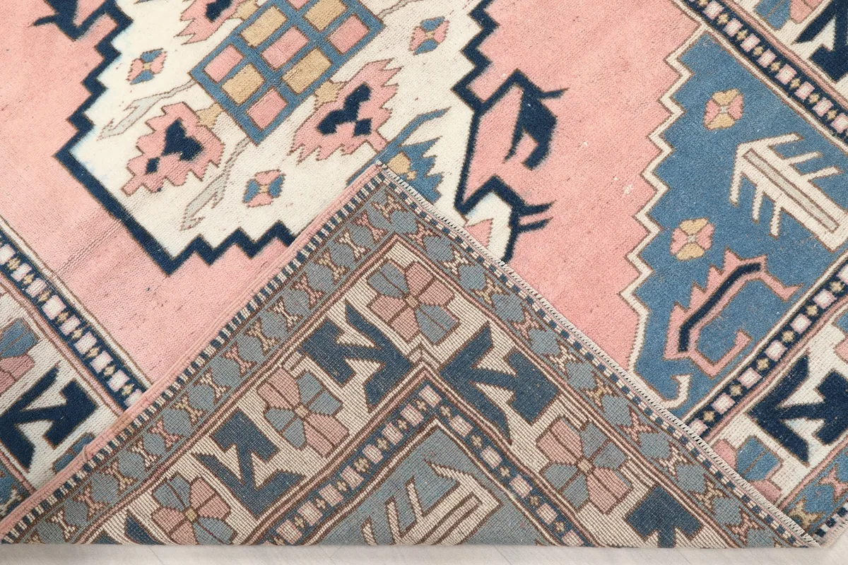 Corner of the rug folded to show the hand-knotted construction and pile texture