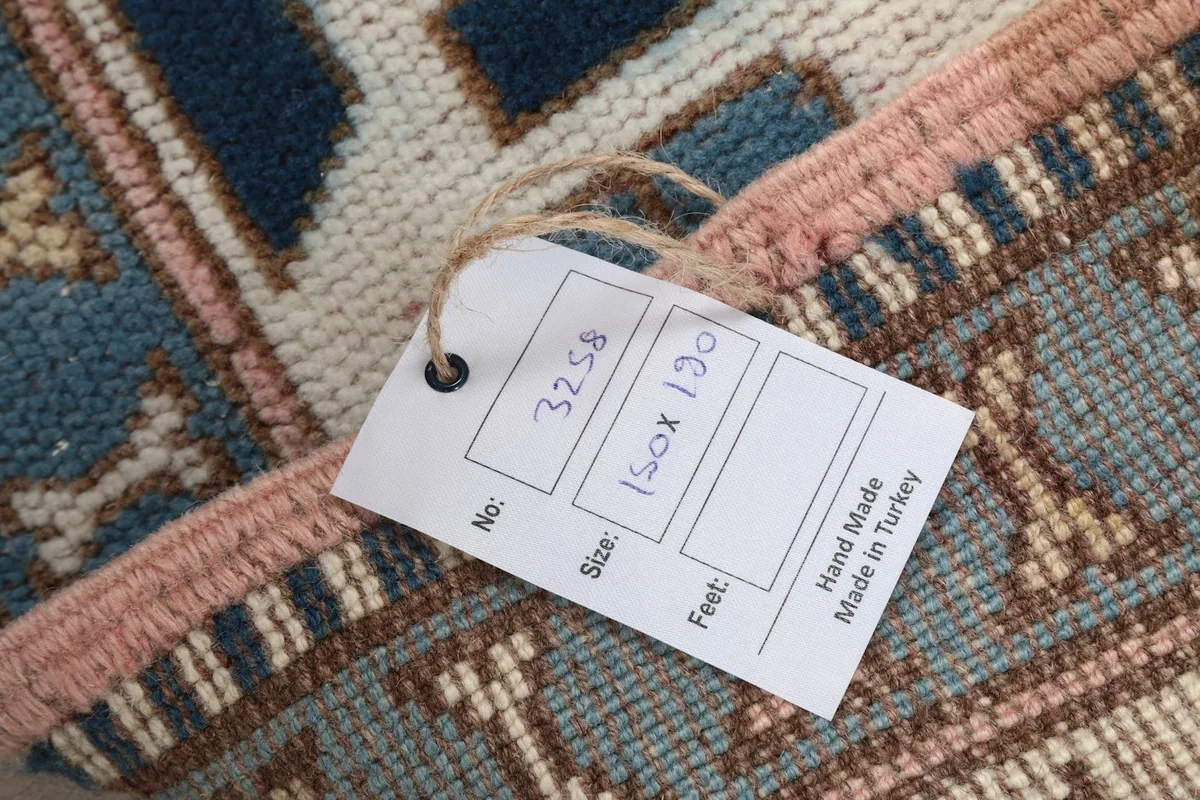 Close-up of the rug's label showing the size 150x190 cm and 'Hand Made in Turkey'