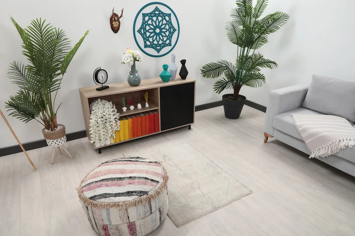 Angle view of the beige and blue vintage rug in a living space, showing its size relative to a sofa and ottoman