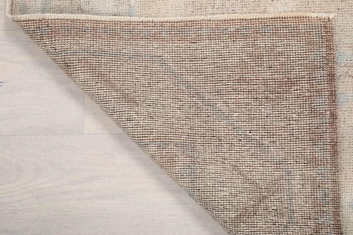 Underside view of the rug, revealing the tightly woven cotton foundation and hand-knotted construction