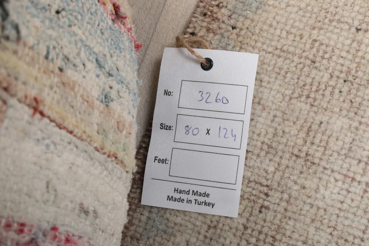 Close-up of the product tag indicating the rug's size in centimeters and origin from Turkey