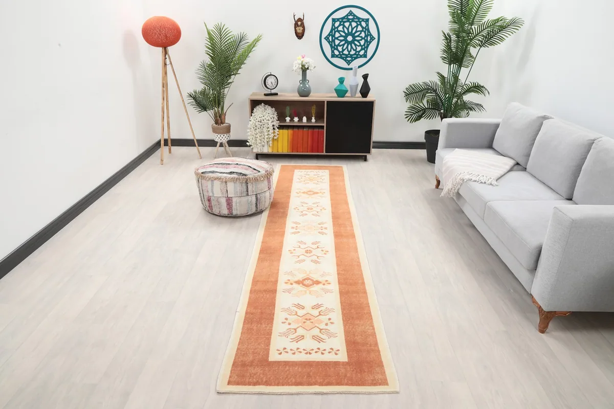 Vintage Anatolian runner rug displayed in a living room setting, showing its length and scale