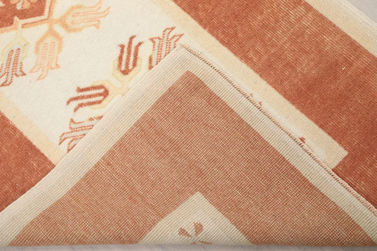 Folded corner of the rug, revealing the wool pile texture and cotton foundation