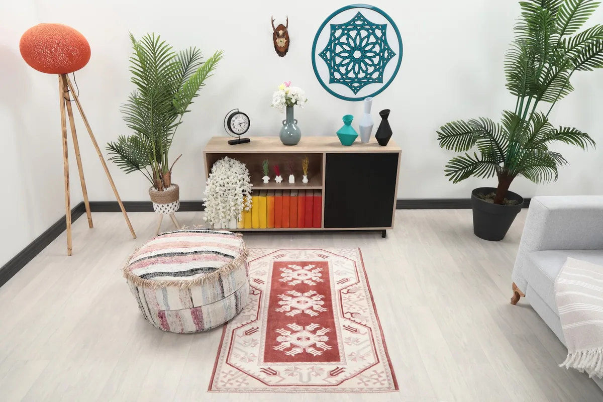 Vintage red and ivory rug in a modern living space with light flooring and minimalist furniture