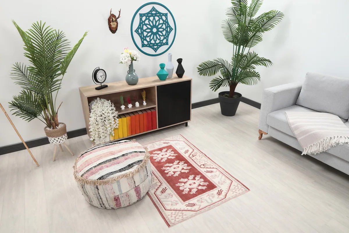 Overhead angle of the small area rug placed in a room setting with a light gray couch and ottoman