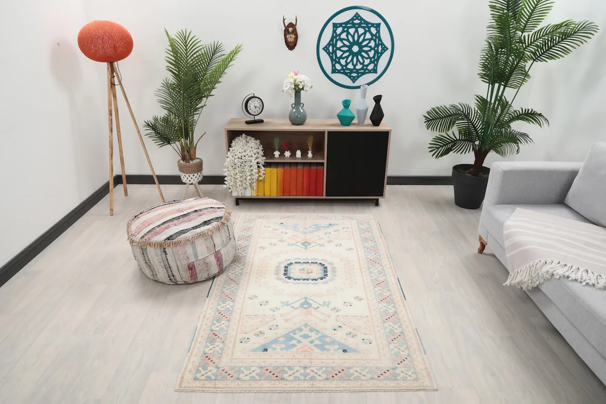 Vintage Anatolian rug in a modern living room setting, showcasing its size and colors with a gray couch and light wood floor.