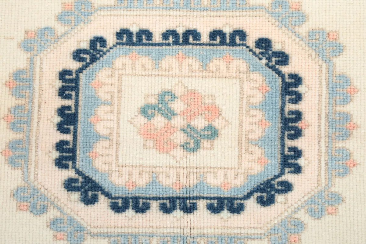 Extreme close-up of the central medallion, showing the hand-knotted wool pile and detailed design.
