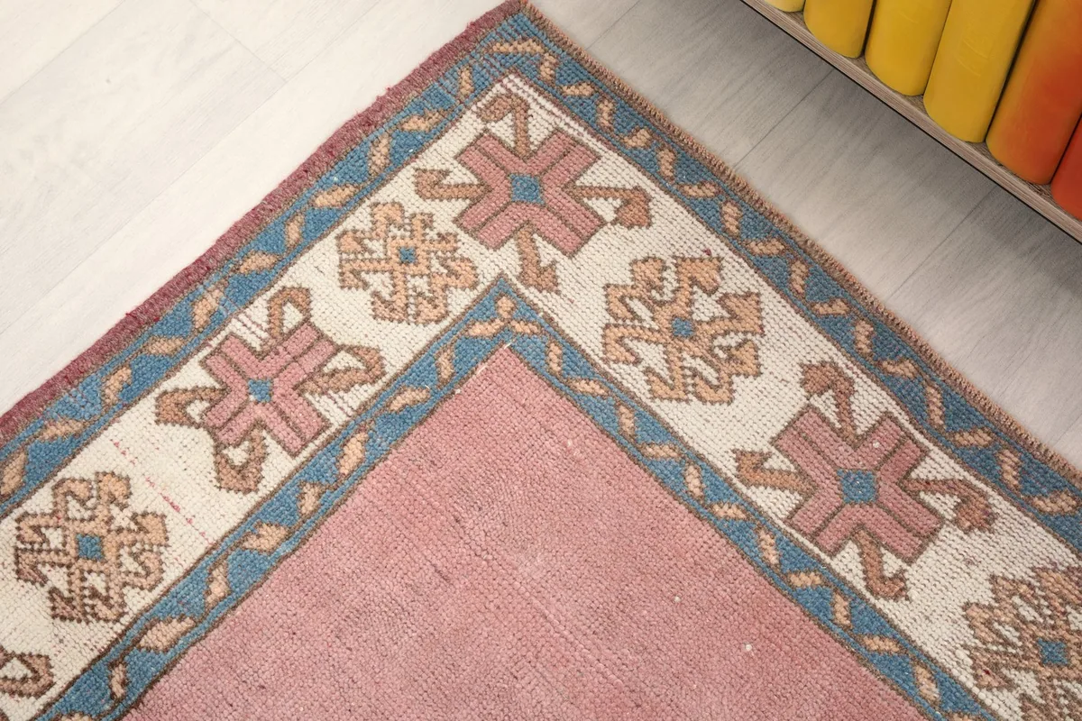 Corner detail of the rug, revealing the intricate border design and colors