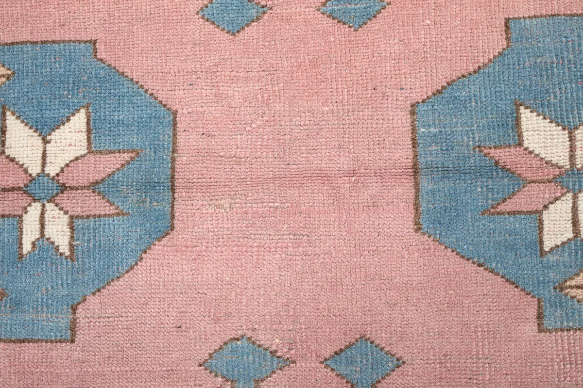 Close-up of the low wool pile and texture of the rose and blue sections