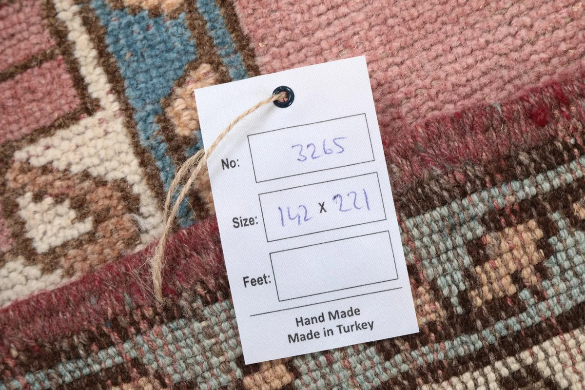 Hand-knotted rug tag showing size 142 x 221 cm and 'Hand Made in Turkey'