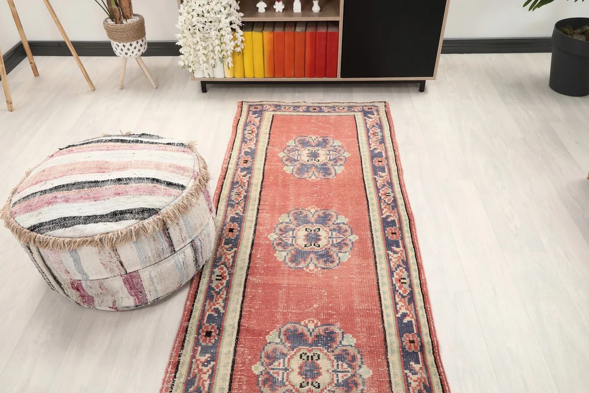 Full view of the rose and navy runner rug in a room setting from a slightly elevated perspective