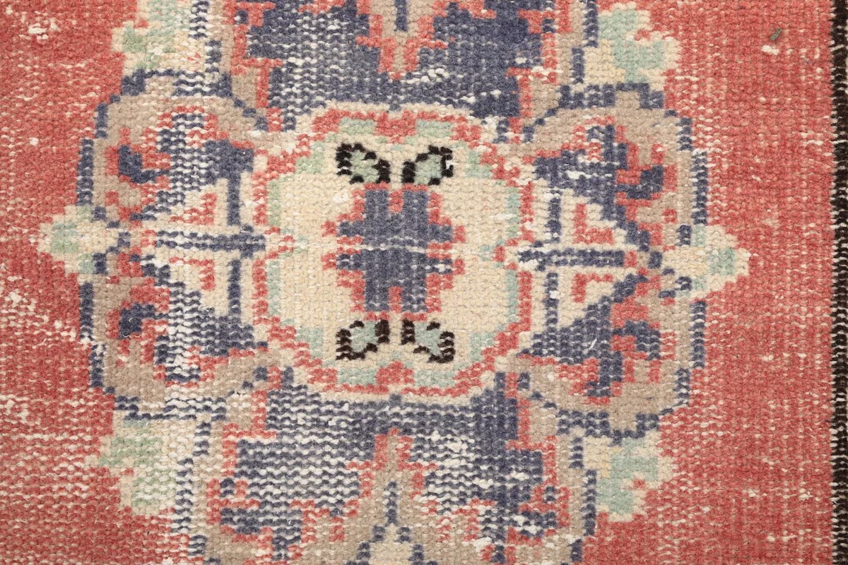 Extreme close-up of a medallion pattern, revealing the hand-knotted wool pile and intricate details