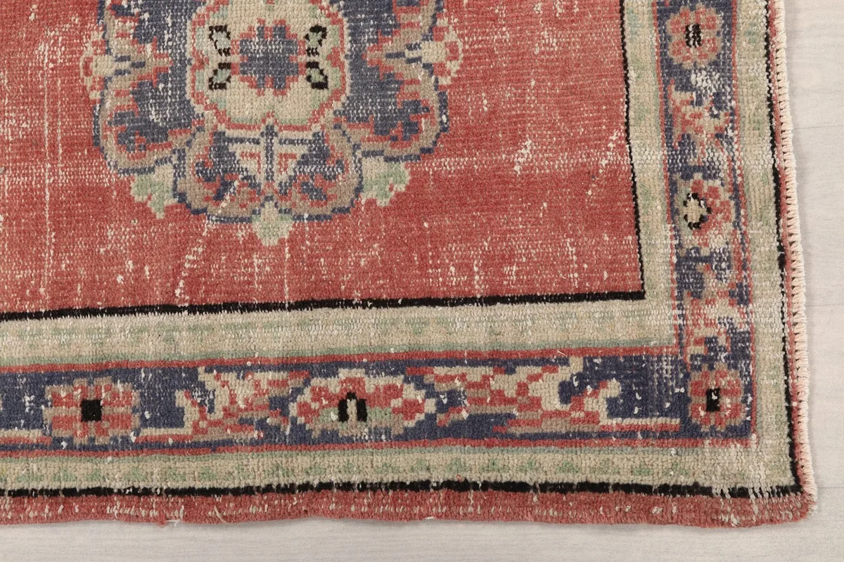 Detail view of the corner of the rug, highlighting the navy and beige geometric border design