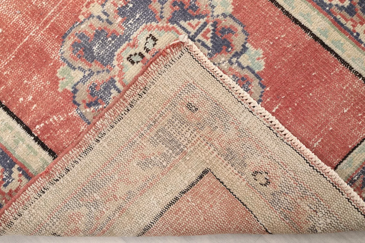Folded corner of the rug revealing the hand-knotted wool pile on a cotton foundation