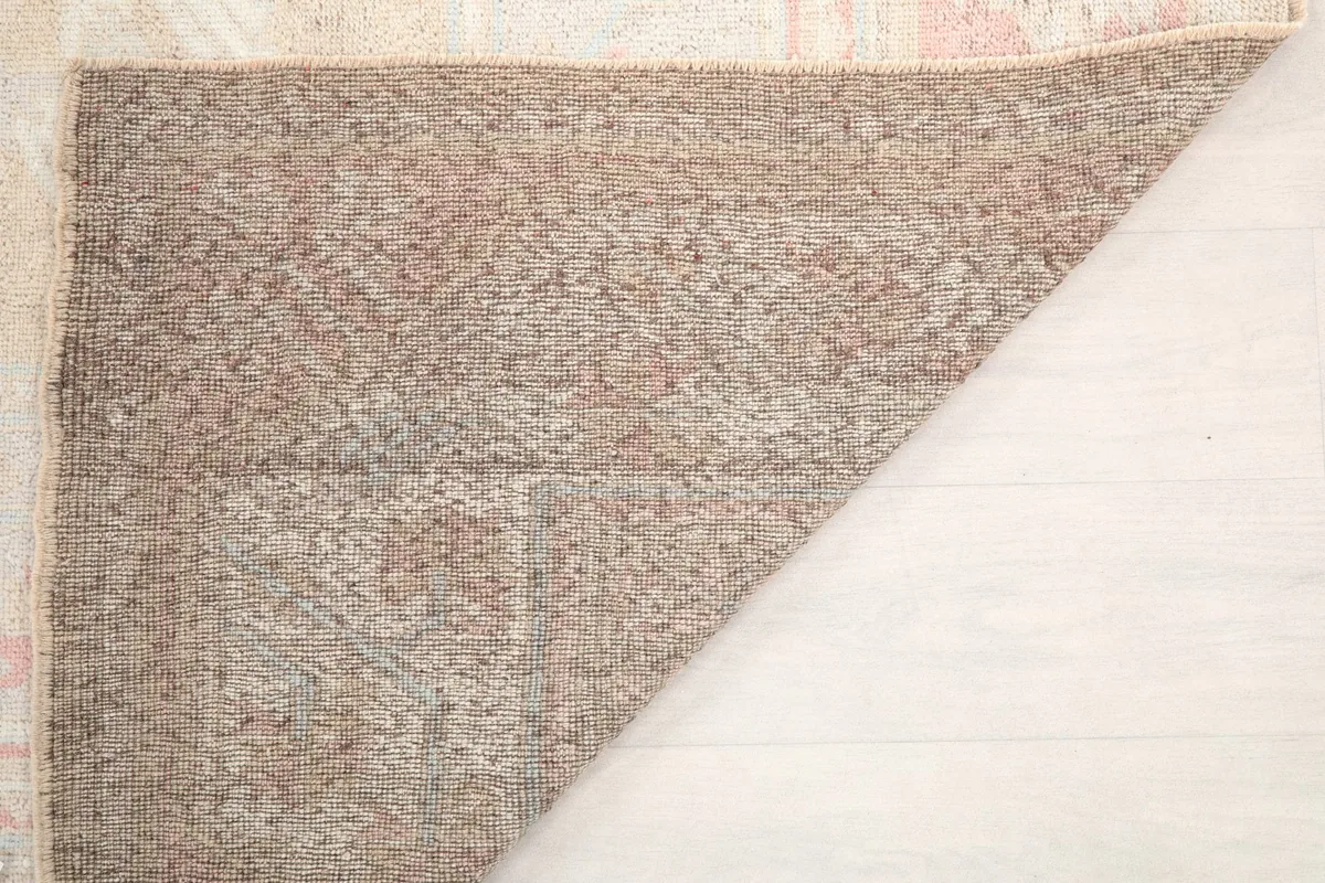 Underside of the hand-knotted wool rug, showing the cotton foundation