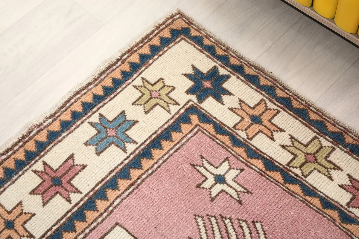 Close-up of the rug's corner, detailing the star-patterned border in various colors.
