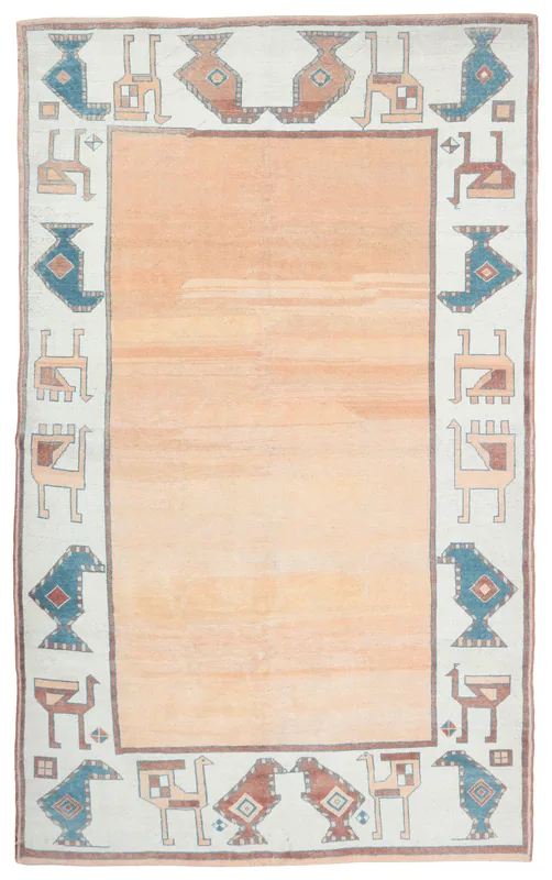 Full overhead view of the vintage orange and ivory Anatolian area rug with tribal geometric border