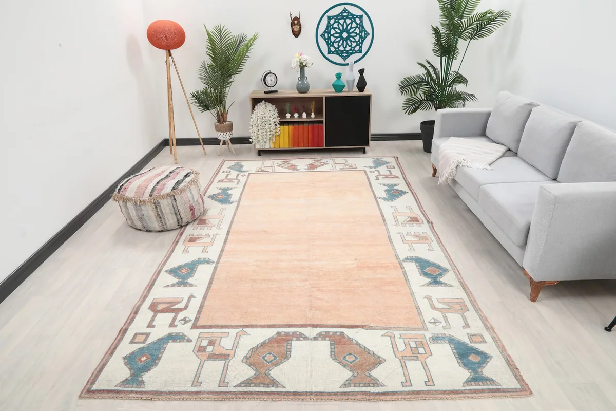 Large orange and ivory vintage rug displayed in a modern living room setting