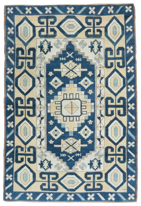 Full overhead view of the navy and beige vintage Anatolian wool rug on a white background.