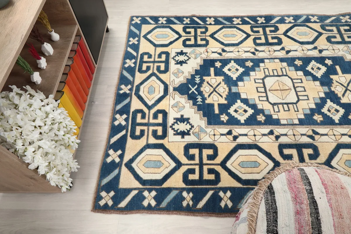 View of the rug from an angle, showing its texture and pattern alongside a wooden cabinet.