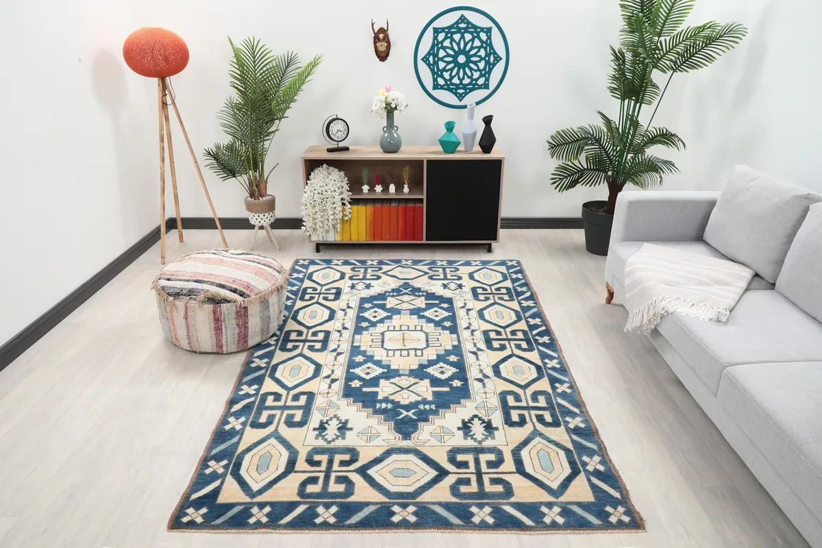 Vintage navy and beige rug placed in a modern living room setting, viewed from an angle.