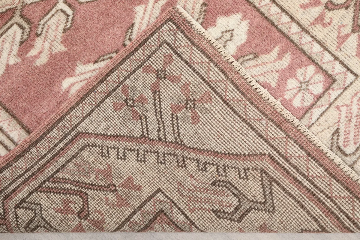 Folded corner of the rug, revealing the tightly woven back and foundation