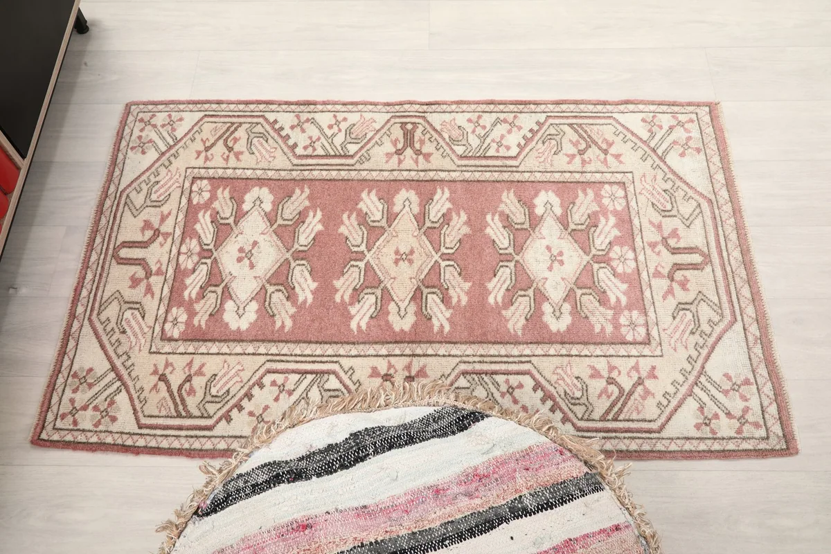 Full overhead shot of the rose and ivory rug, showcasing its overall pattern and shape