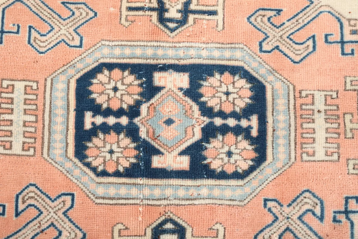 Close-up detail of the central navy and rose medallion with intricate floral patterns