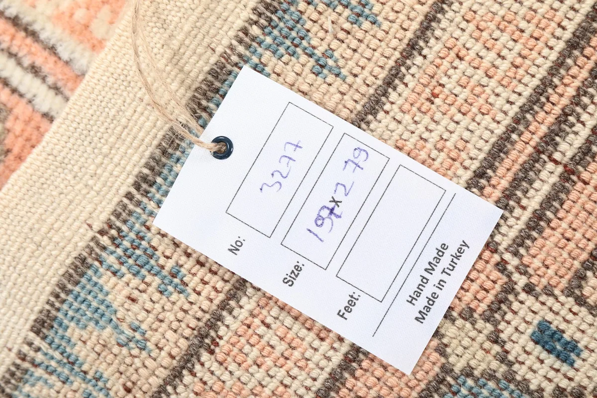 Close-up of the rug's back with a tag, showing the hand-knotted structure and material