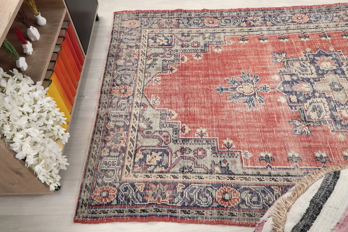 Angle view of the rug's full length, showing its design and aged appearance