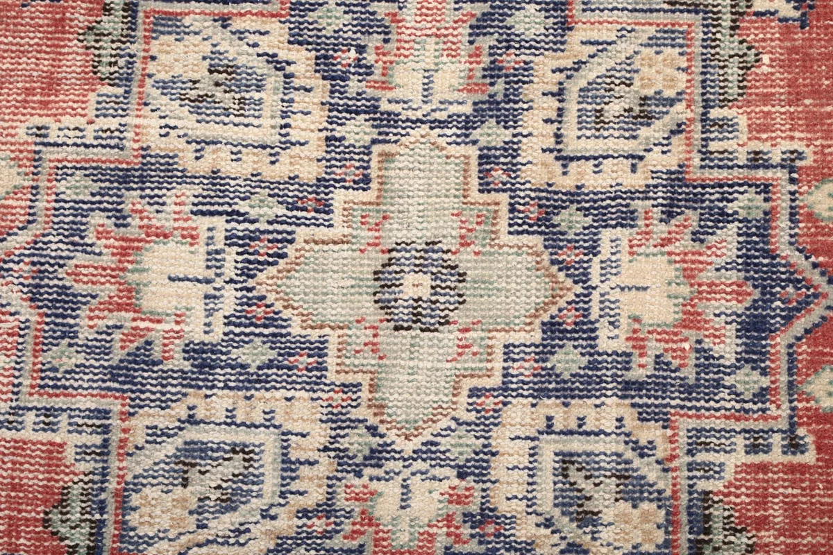 Extreme close-up of the central medallion design showing navy, beige, and gray colors