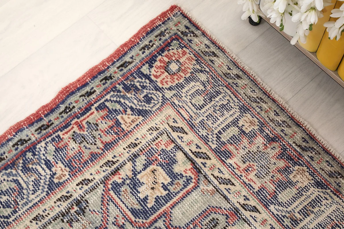 Corner detail of the rug's border, revealing intricate patterns and color variations