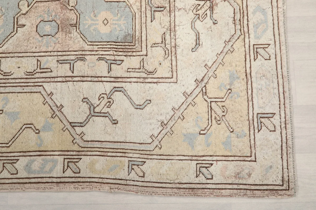 Detailed shot of the corner and border of the vintage rug, highlighting the geometric patterns and gentle wear.