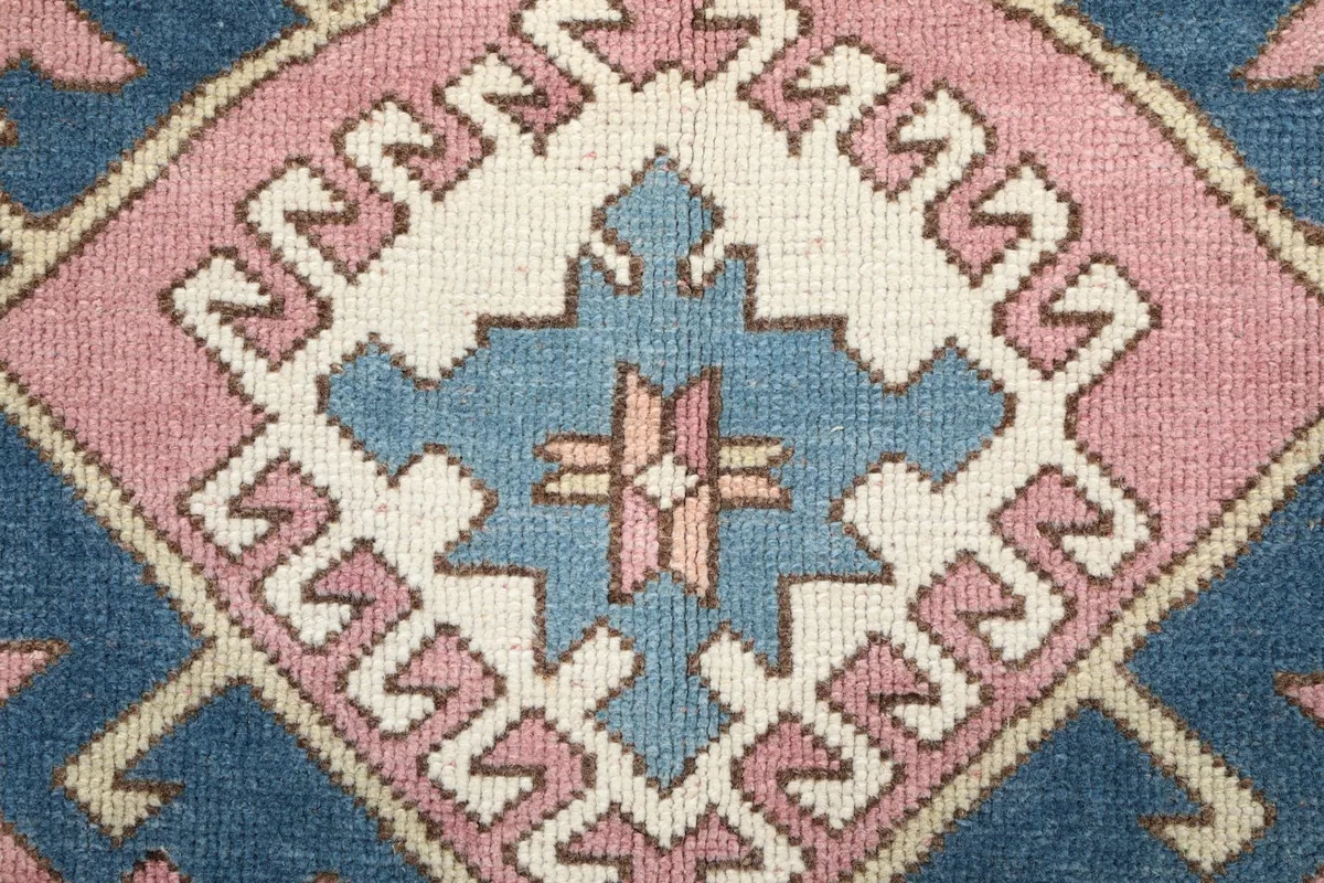 Tight close-up of the intricate weaving and color variations within a central geometric medallion.
