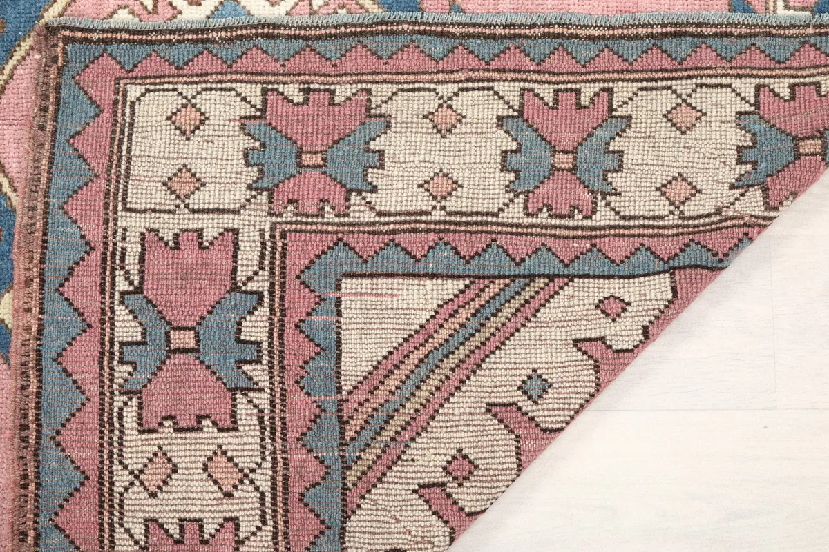 Close-up of the rug's back, showing the tight knotting and construction of the wool on cotton foundation.