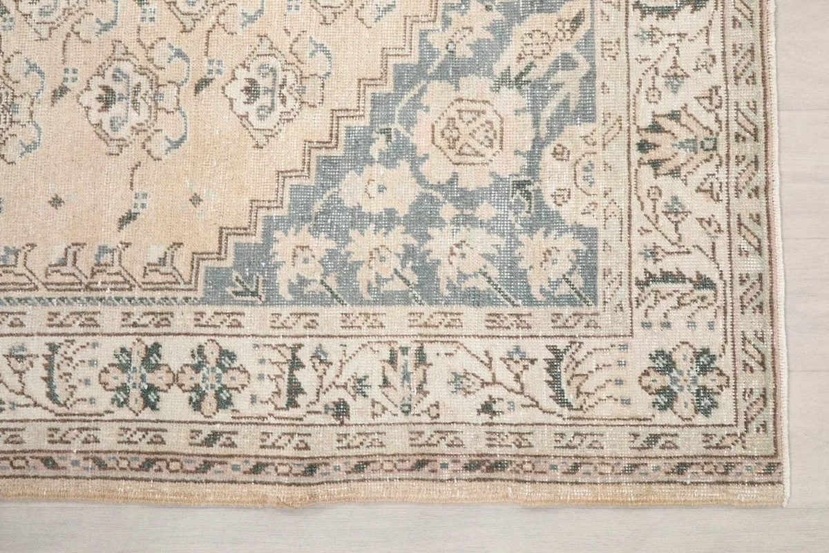 Detailed view of the corner border and a section of the blue pattern within the rug