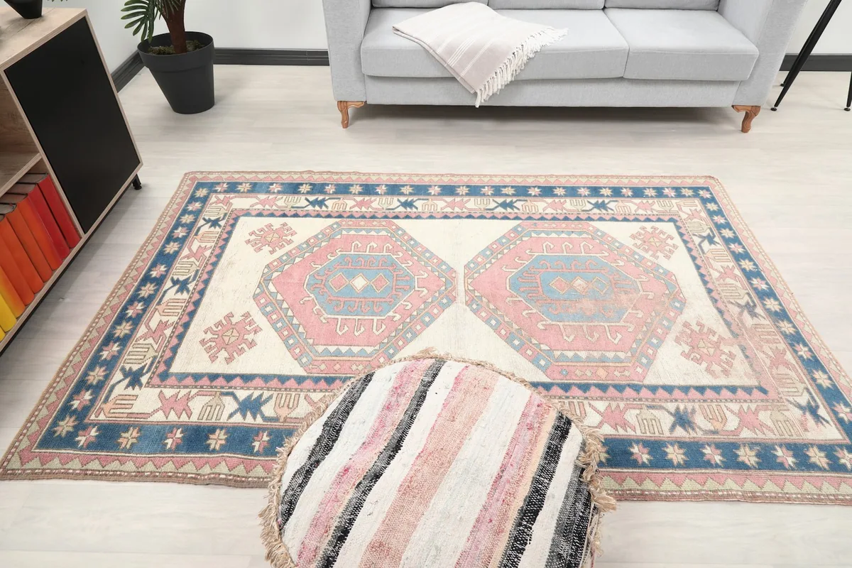Overhead view of the rug in a living room, with a light gray sofa and a striped ottoman