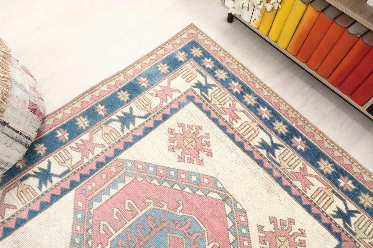 Corner detail of the rug, highlighting the geometric patterns within the ivory field and border
