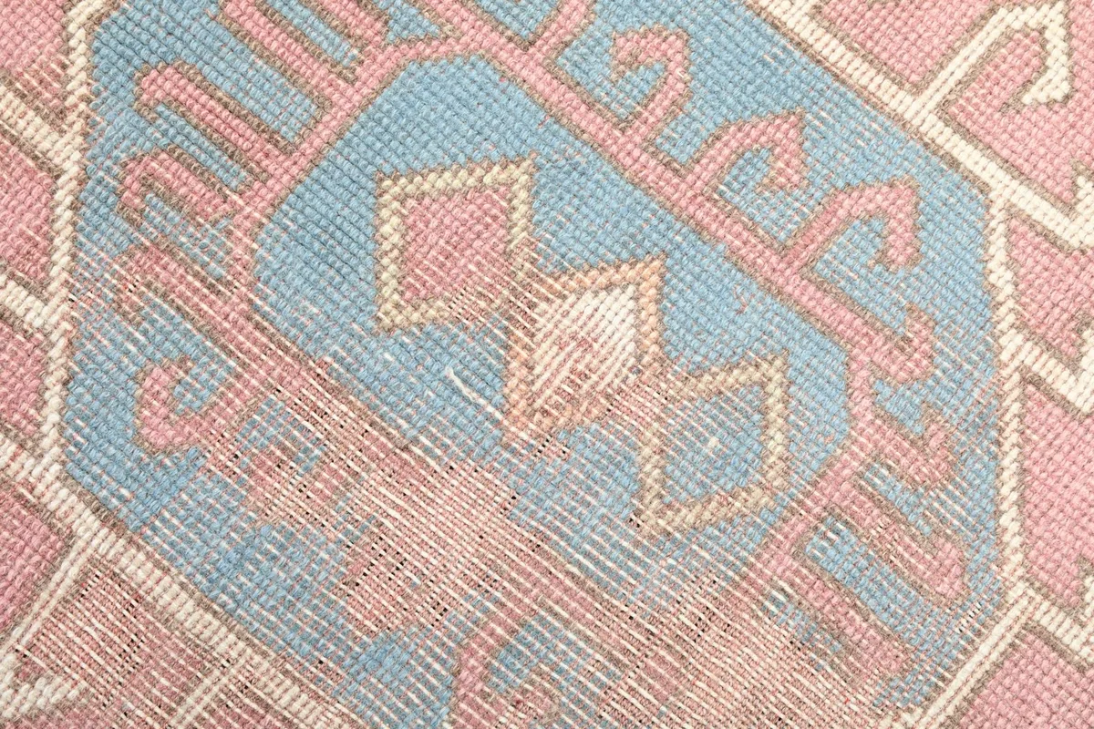 Macro shot showing the low pile and texture of the pink and blue wool knots