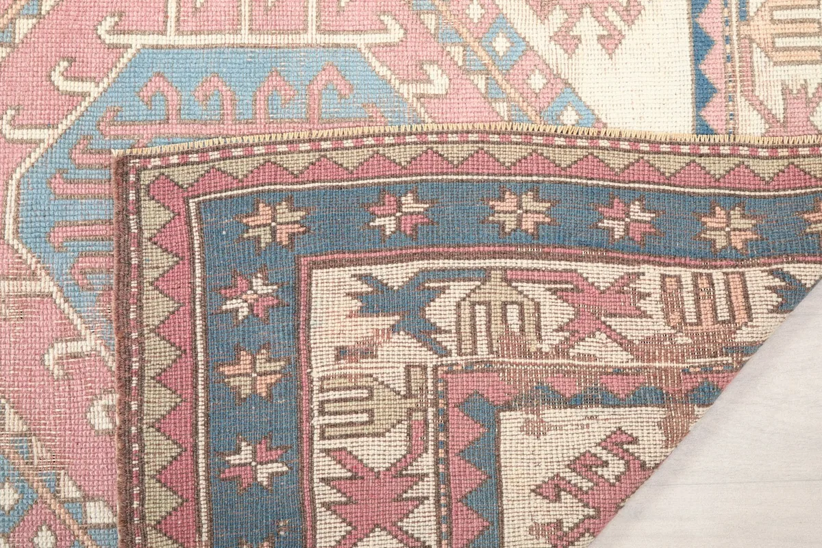 Close-up of the rug's back, revealing the hand-knotted cotton foundation and wool knots