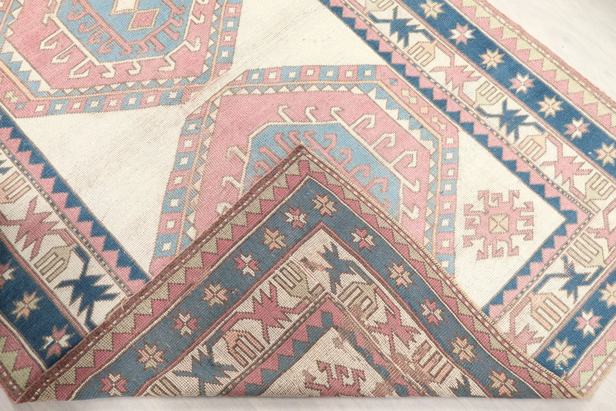 View of the rug folded back to show the cotton foundation and reverse side of the knots