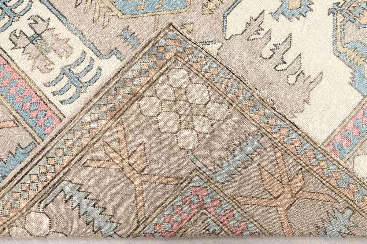 Corner of the rug folded back, showing the back of the hand-knotted construction