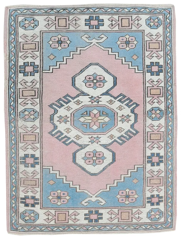 Full overhead view of the vintage pink and blue Anatolian rug on a white background