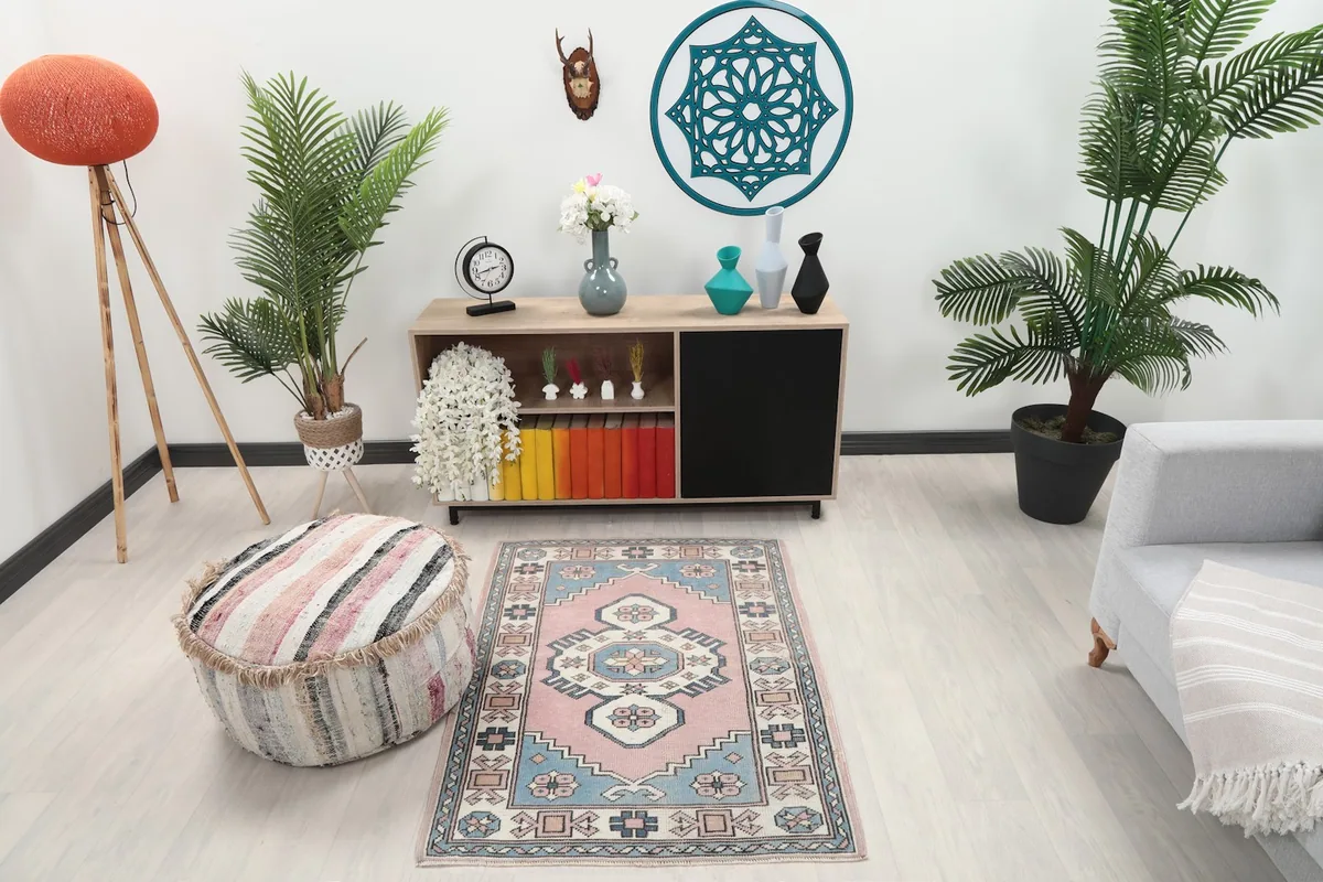 Vintage pink and blue rug placed in a modern living space with light furniture