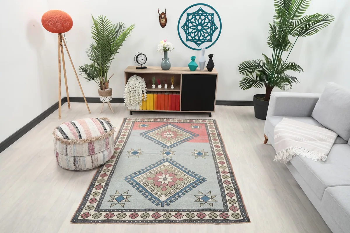 Vintage Anatolian rug in a room setting with a light gray sofa and wooden cabinet
