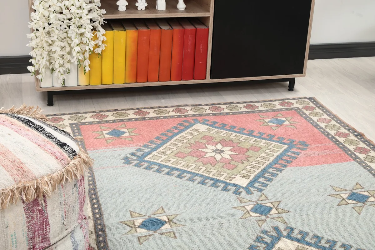Close-up view of the rug's geometric patterns and rose section in a room setting
