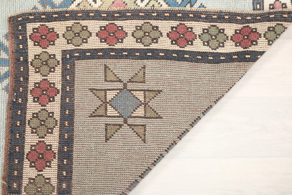Another folded corner view, revealing the back of the vintage wool rug and its construction