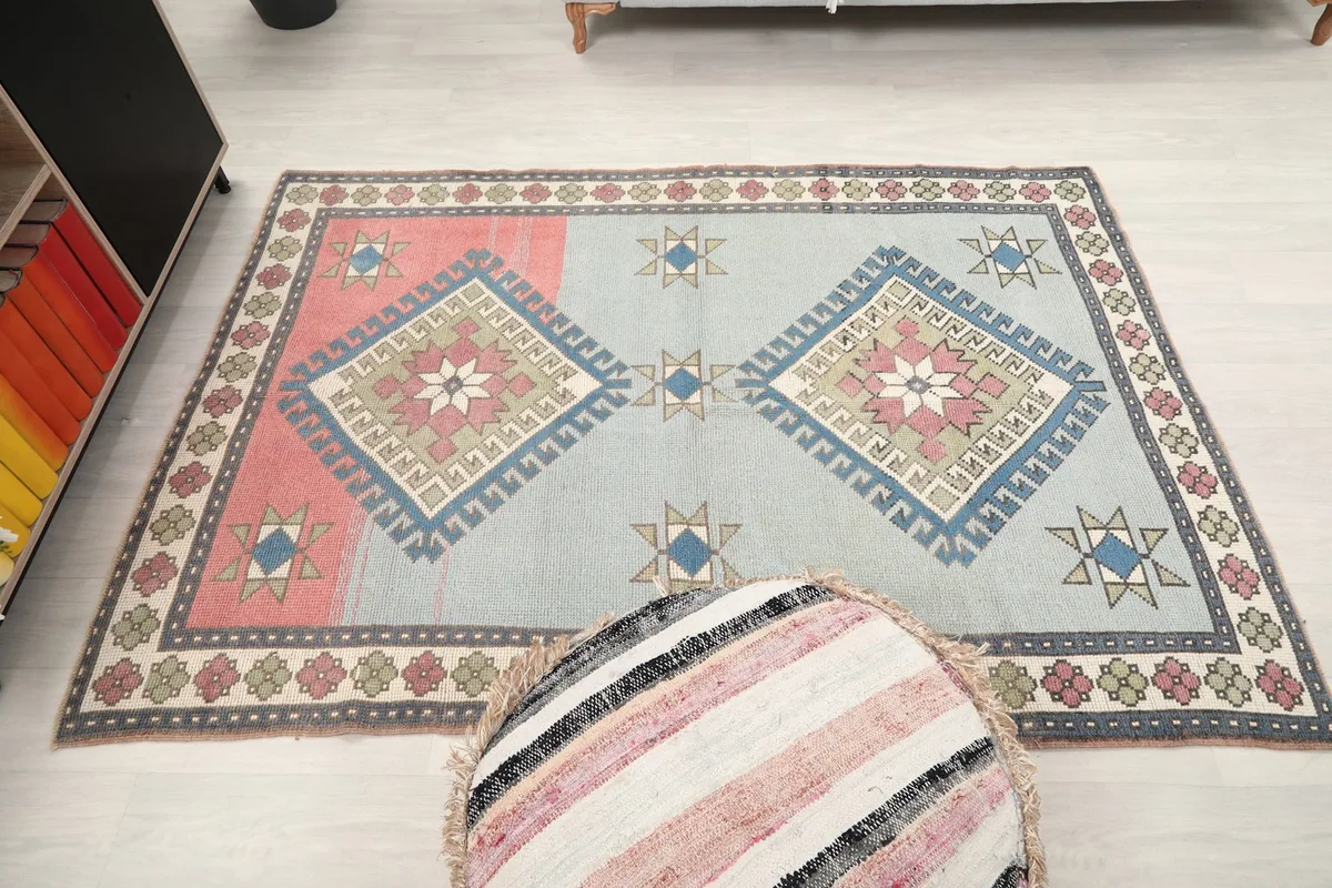 Full overhead shot of the rug with a decorative ottoman in the foreground